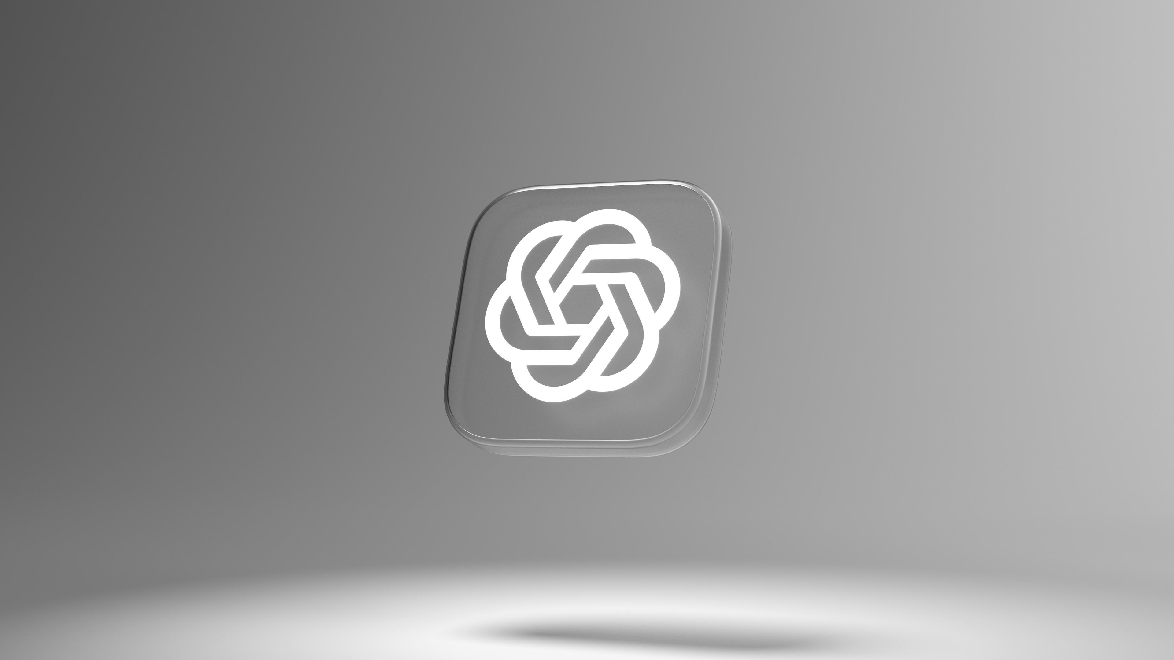 A glowing white OpenAI logo icon on a dark gray tile, floating against a gray gradient background