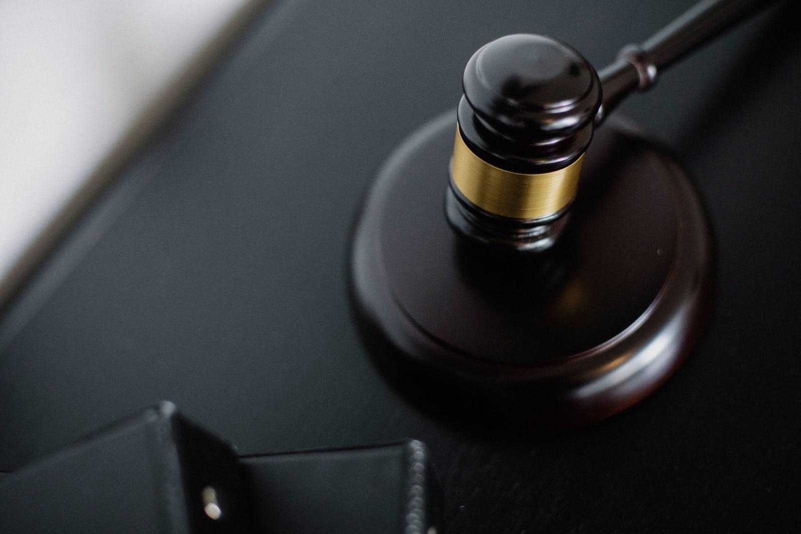 A wooden gavel resting on its sound block on a dark desk, symbolizing a courtroom lawsuit